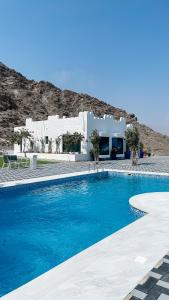 una piscina frente a una casa blanca en Moon mountain villa, 