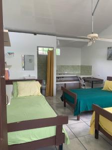 a bedroom with two beds and a table and a sink at Casa Natalia in Herradura