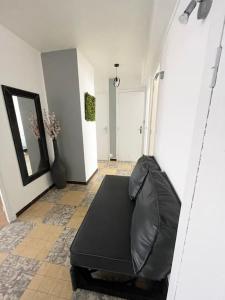 uma sala de estar com um sofá preto num quarto em Somptueux appartement proche centre & transports em Villeurbanne