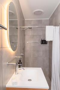 W łazience znajduje się umywalka i lustro. w obiekcie Palm View Holiday Apartments w mieście Bowen