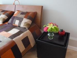 a vase of flowers on a table next to a bed at Stunning SanFran Casa close to Center and steps from Ocean in San Francisco