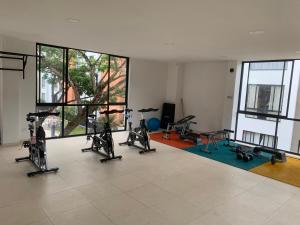 einen Fitnessraum mit Laufbändern und Heimtrainern in einem Zimmer in der Unterkunft Apartamento Santafe cartago V in Marinita