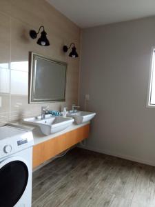 une salle de bain avec deux lavabos et un miroir dans l'établissement franklin chapel, à Clarks Beach 25 autres photos