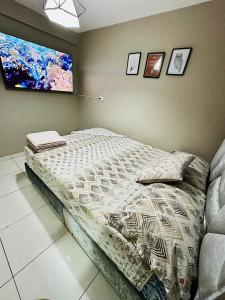 een slaapkamer met een bed en een tv aan de muur bij Aparta estudio cerca al aeropuerto el Dorado in Bogota
