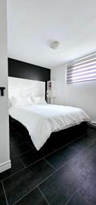 una camera da letto con un letto grande con lenzuola bianche di Havre AquaMont Piscine & Spa a Sainte Brigitte de Laval