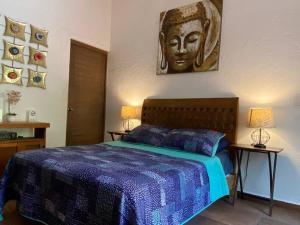 1 dormitorio con 1 cama con manta azul y 2 lámparas en Casa Brisa en Burgos Cuernavaca, en Temixco
