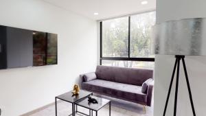 - un salon avec un canapé violet et une table dans l'établissement Lujoso Apto 2 habitaciones Chico Comfort, à Bogotá