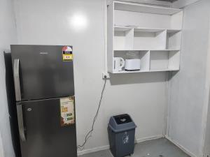 eine Küche mit einem Kühlschrank und einem Mülleimer in der Unterkunft GoodWorks Accommodation in Yangor