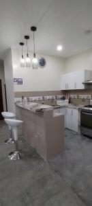 a large kitchen with white cabinets and a large island at La casita Azul - Río Mar - Iquitos in Iquitos