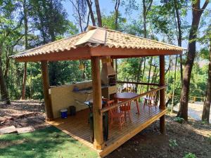 einen Pavillon mit einem Tisch und Stühlen auf einer Terrasse in der Unterkunft Casa dos Flinstones, Vila Mágica in Bueno Brandão