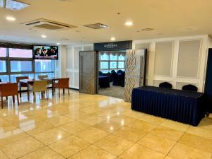 un vestíbulo con mesa, sillas y TV en J-Grand Hotel en Jeju