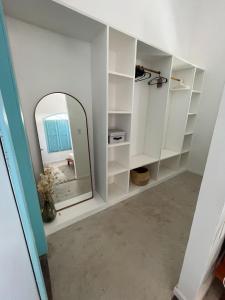 a dressing room with a mirror and white shelves at Villa Parazinho in Paracuru
