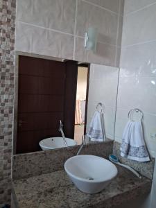 a bathroom counter with a sink and a mirror at Excelente casa a 3km do centro de Itabira in Itabira