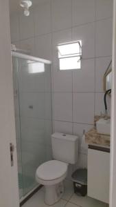 a white bathroom with a toilet and a sink at Casa de Veraneio em Itapema - BA in Santo Amaro