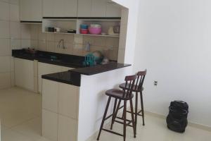 a kitchen with two bar stools and a counter at Casa de Veraneio em Itapema - BA in Santo Amaro