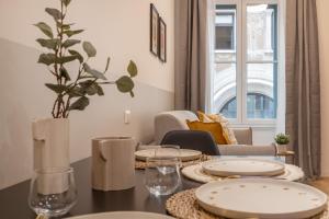 un comedor con una mesa con platos. en Trieste Timeless 2-bedrooms flat, en Trieste