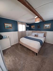 um quarto com uma cama grande e paredes azuis em Lower River Retreat em Parker