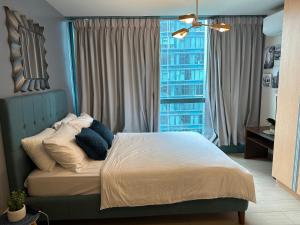 a bedroom with a bed with a large window at Executive Suite in Bonifacio Global City in Manila