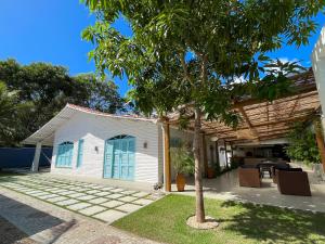 a white house with a tree in the yard at Villa Parazinho in Paracuru