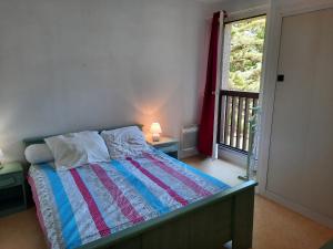 1 dormitorio con 1 cama, ventana y puerta en Appartement Seignosse, 2 pièces, 4 personnes - FR-1-239-813, en Seignosse