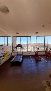 un gimnasio con 2 cintas de correr en un edificio con ventanas en dpto pleno centro turístico de viña del mar, en Viña del Mar
