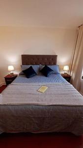 um quarto com uma cama grande e 2 candeeiros em dpto pleno centro turístico de viña del mar em Viña del Mar