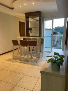 eine Küche mit einem Tisch und Stühlen im Zimmer in der Unterkunft Apartamento confortável próximo Vila Germânica in Blumenau