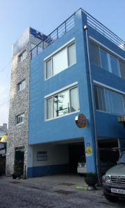 釜山的住宿－釜山國際會展中心旅舍，蓝色的建筑,前面有停车位