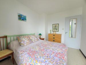 a bedroom with a bed with a colorful comforter at Appartement Argelès-sur-Mer, 2 pièces, 4 personnes - FR-1-309-386 in Argelès-sur-Mer