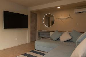a living room with a couch and a flat screen tv at Casa con vista a la bahía in Acapulco