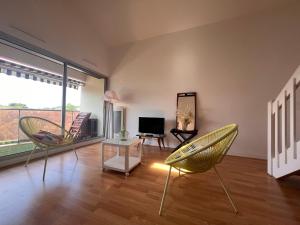 ein Wohnzimmer mit 2 Stühlen und einem TV in der Unterkunft Appartement Saint-Jean-de-Luz, 2 pièces, 4 personnes - FR-1-239-974 in Saint-Jean-de-Luz