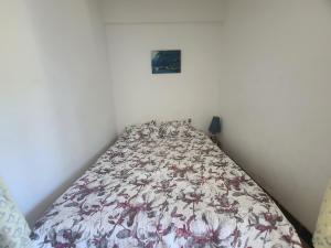a bedroom with a bed with a floral bedspread at Studio Argelès-sur-Mer, 1 pièce, 4 personnes - FR-1-309-398 in Argelès-sur-Mer