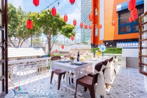 a table and chairs on a patio with red lanterns at Villa GOLD DAY Hồ bơi LÊ HỒNG PHONG Nối dài in Vung Tau