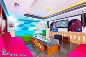 a living room with pink furniture and a large aquarium at Villa GOLD DAY Hồ bơi LÊ HỒNG PHONG Nối dài in Vung Tau