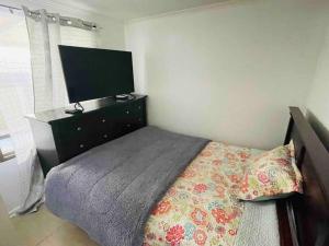 a bedroom with a bed with a dresser and a television at Casa Aislada Peñaflor-Malloco in Santiago