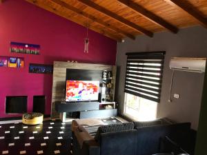 a living room with a couch and a flat screen tv at Departamento Oberá amplio zona centro in Oberá