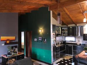 a kitchen with black cabinets and a green wall at Departamento Oberá amplio zona centro in Oberá