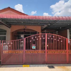 a red gate in front of a building at Mahsuri Homestay in Jitra
