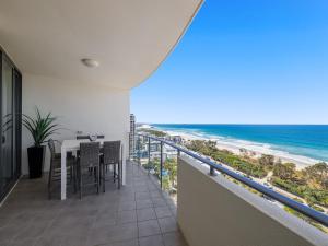 a balcony with a table and chairs and the ocean at Beach on Sixth in Maroochydore