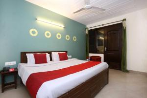 - une chambre dotée d'un grand lit avec des oreillers rouges et blancs dans l'établissement OYO Flagship Hotel Sangam 45, à Chandigarh