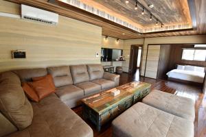 a living room with a couch and a table at Seven Residence Music in Nago