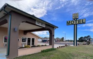 una señal de motel frente a un edificio en Ozark Inn, en Mena