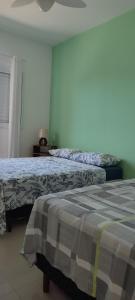 a bedroom with two beds and a window with a bedspread at Casa com piscina duas quadras da praia in Guaratuba