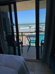 a bedroom with a balcony with a view of the beach at Oceanfront on Daytona Beach in Daytona Beach Shores +1 photo