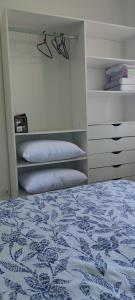 sypialnia z niebiesko-białym łóżkiem i półkami w obiekcie Casa com piscina duas quadras da praia w mieście Guaratuba