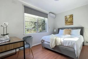 モーウェルにあるMorwell Pet friendly 3BR Retreat Free Parking Netflixのベッドと机と窓のある寝室