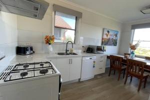 uma cozinha com um fogão e uma bancada em Morwell Pet friendly 3BR Retreat Free Parking Netflix em Morwell