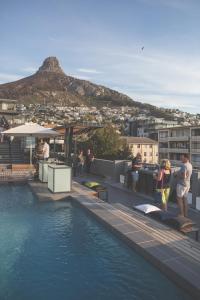 a group of people standing on a rooftop next to the water at 4a Tenonq in Cape Town