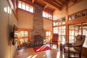 a living room with a stone fireplace and windows at 【飛騨高山】kiyomi荘-sou- 贅沢なプライベート空間 in Takayama