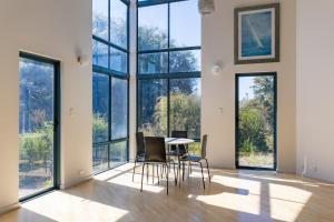 Cette chambre dispose d'une table, de chaises et de grandes fenêtres. dans l'établissement Cosy Corner by the BnB Collection, à Albany